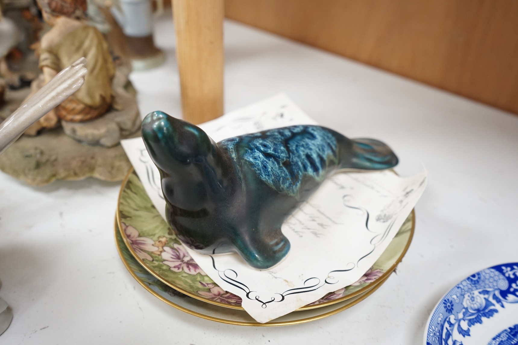 A collection of pottery and porcelain to include a Hayle model of a seal, Lladro figures and a pair of Fairy cabinet plates, largest 27cm wide